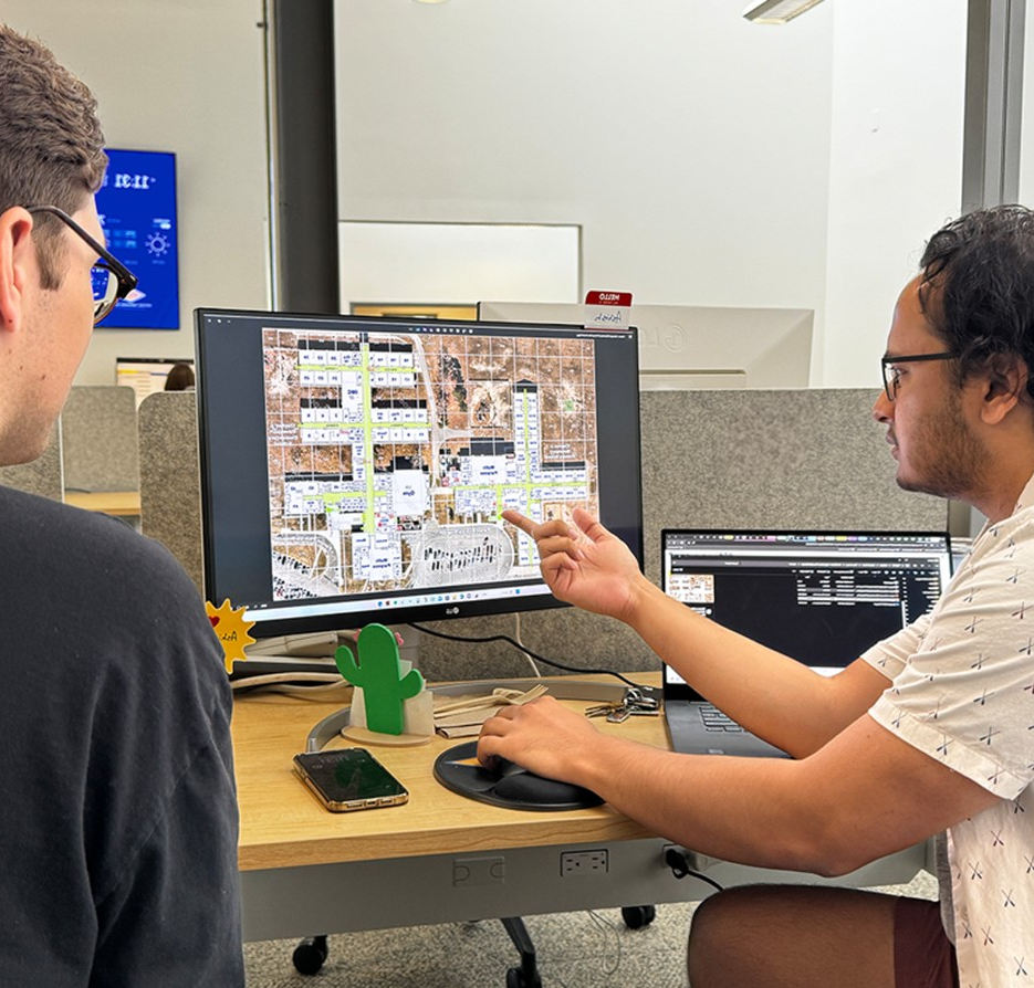 Mapping specialists reviewing a site plan on a workstation